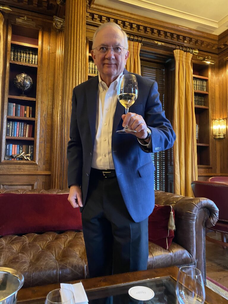 James R. Gregory holding glass of wine